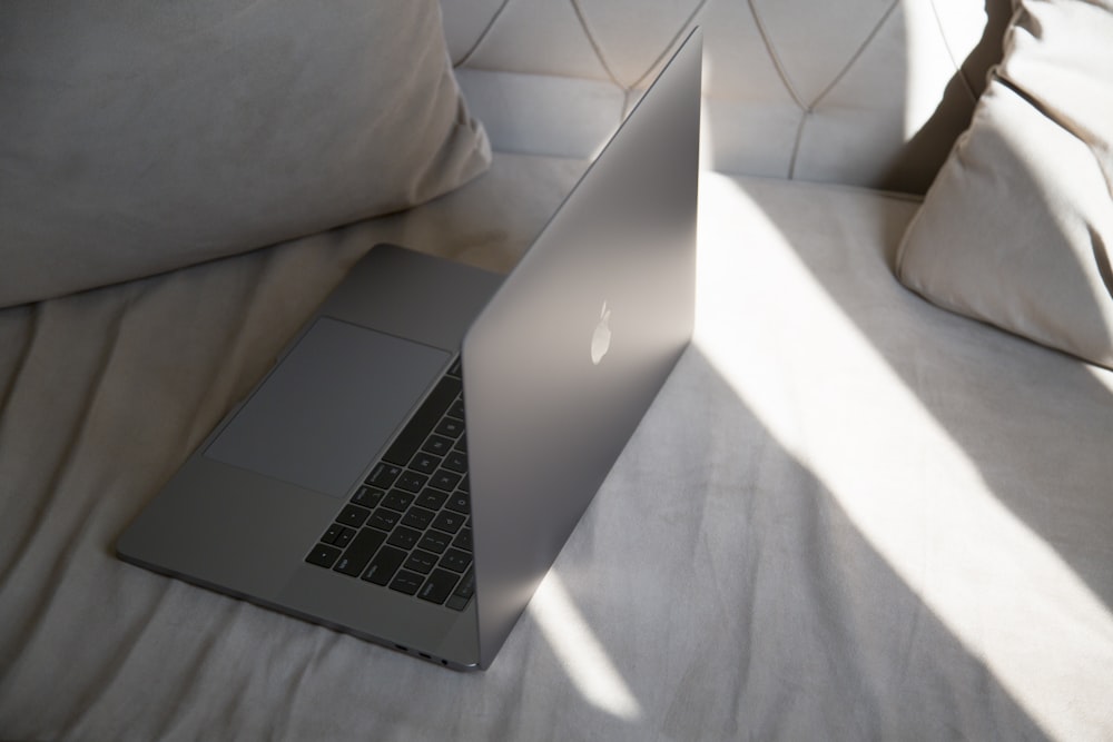 a laptop computer sitting on top of a bed