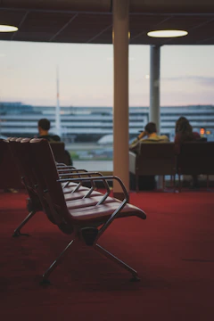 Modern aluminium recliner chairs arranged neatly in a bright airport waiting lounge.