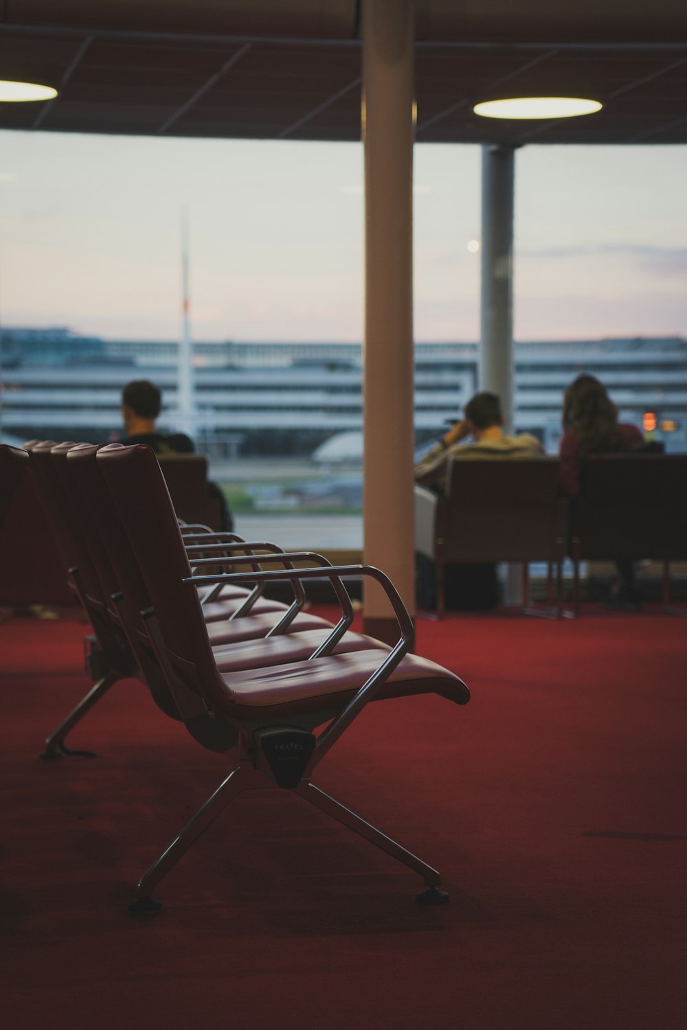 a row of chairs sitting on top of a red carpet