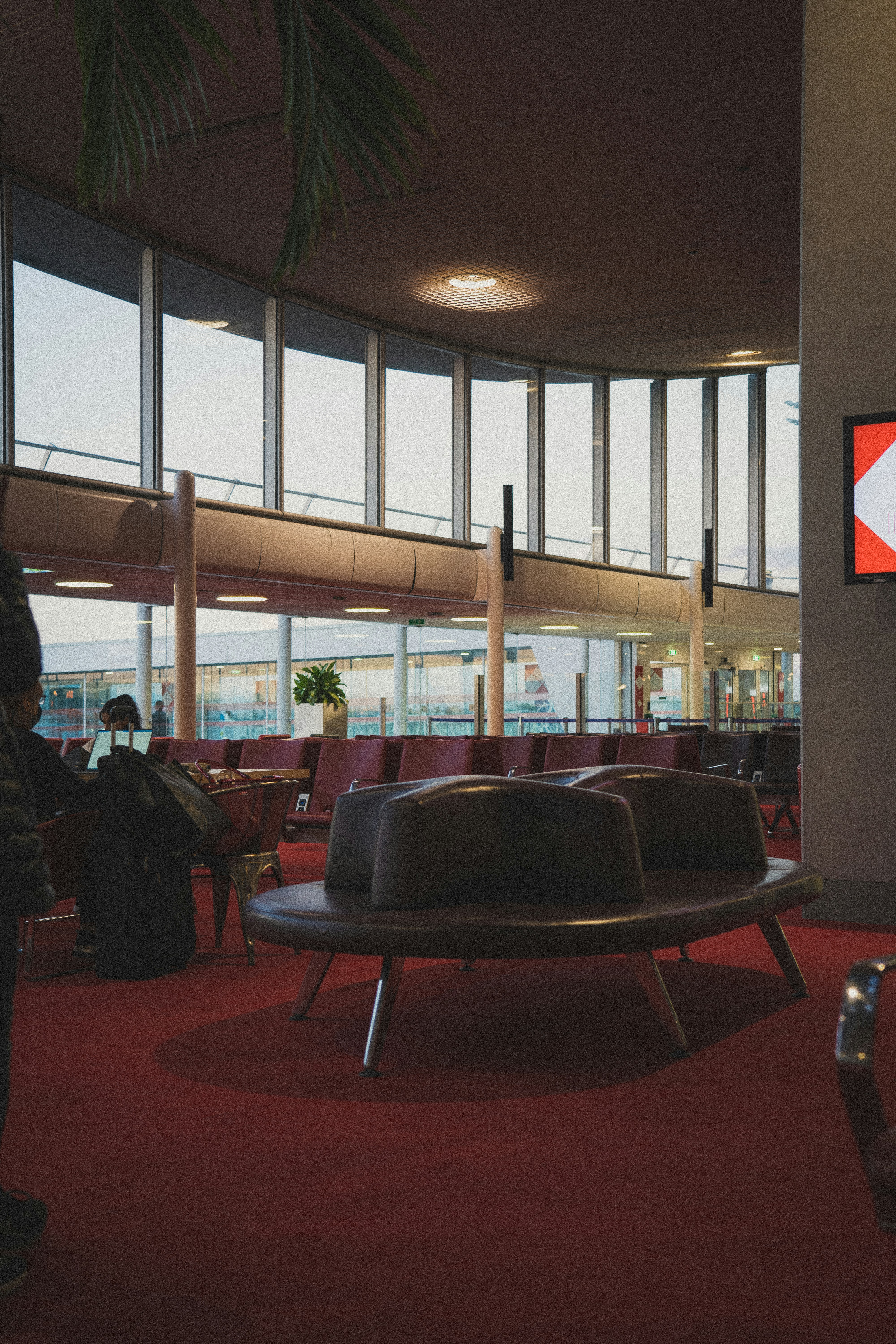 A large room with a red carpet and a large window - best Paris airport to fly into