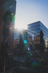 Engineers reviewing blueprints under bright office lights with solar panels outside.