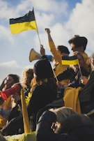 A joyful group of friends laughing together, wearing black and yellow clothing.