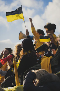 A joyful group of friends laughing together, wearing black and yellow clothing.