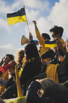 A group of drivers celebrating on the podium, yellow and black flags waving behind them.