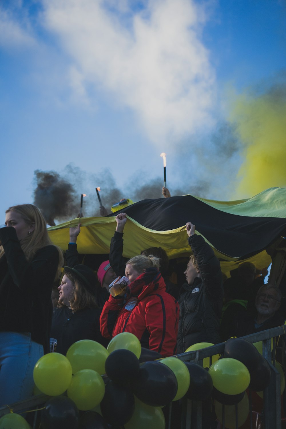 a crowd of people standing around a yellow and black tent