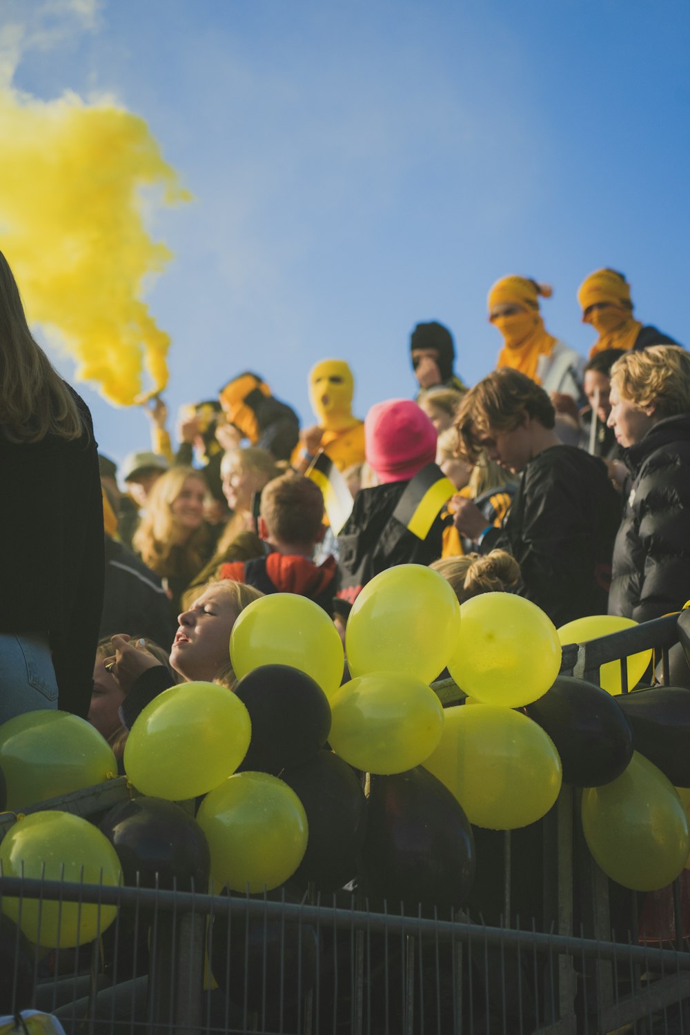 a crowd of people with yellow balloons in front of them