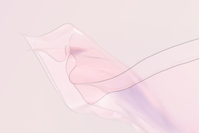 A delicate, translucent fabric flows elegantly with soft, undulating curves. The fabric appears almost weightless, capturing light and creating a soothing visual effect with its gentle movement.