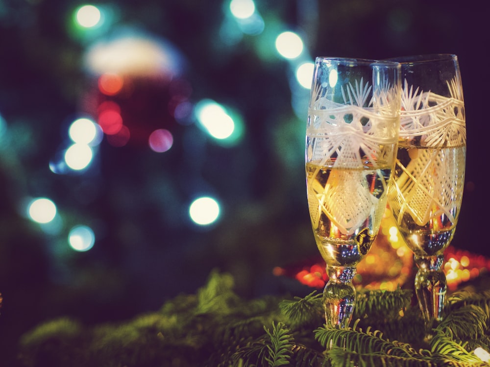 two glasses of champagne sitting on top of a christmas tree