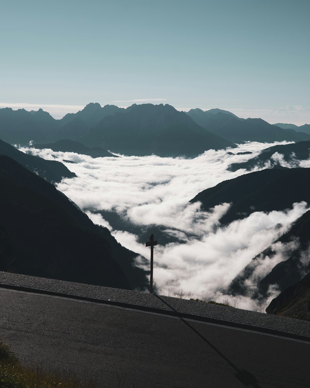 a view of the mountains and clouds from the top of a hill