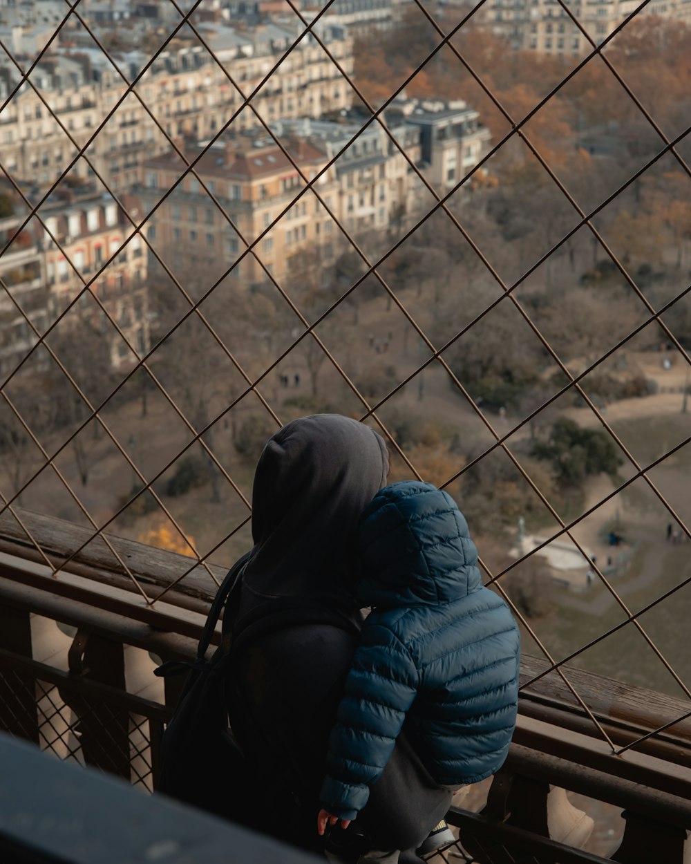 a person in a blue jacket looking out over a city