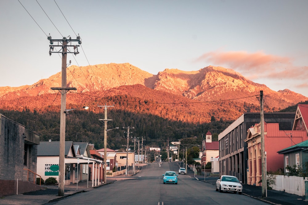 a car driving down a street with a mountain in the background