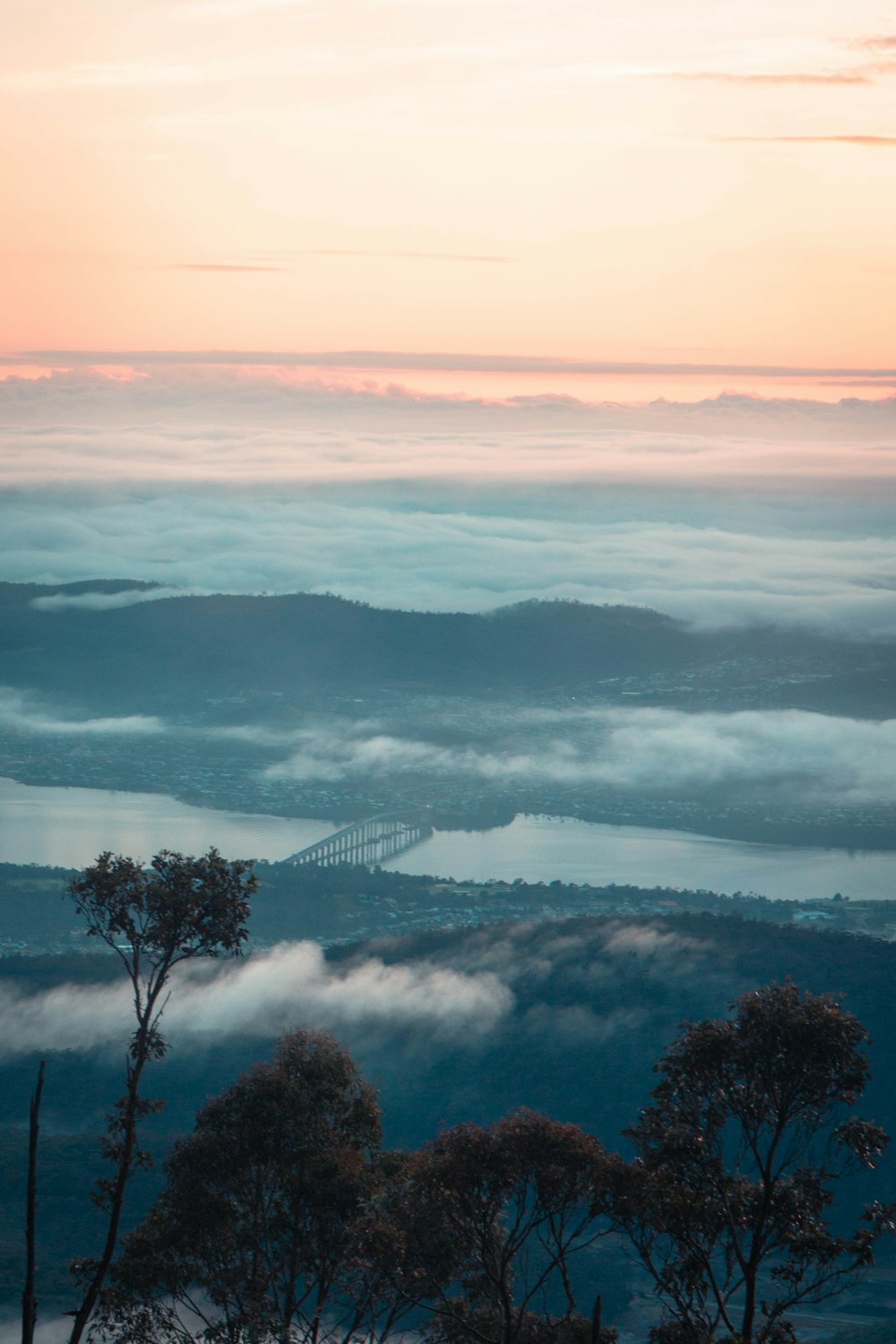 a view of a foggy valley with a bridge in the distance