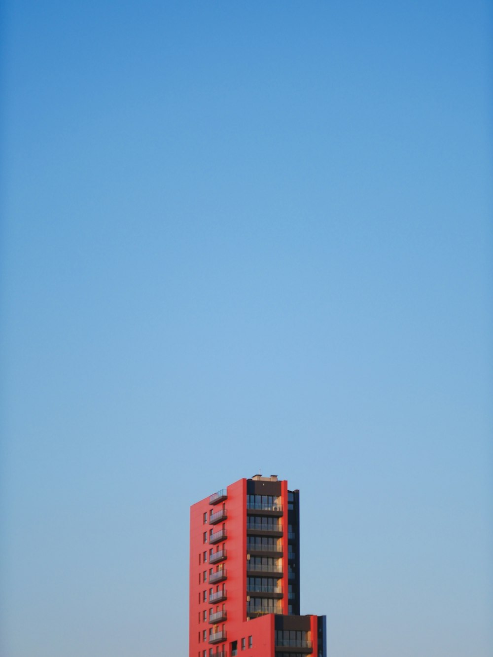 a tall red building sitting on top of a lush green field