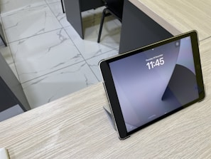 Close-up of a tablet displaying time-lapse aerial images of a building project.