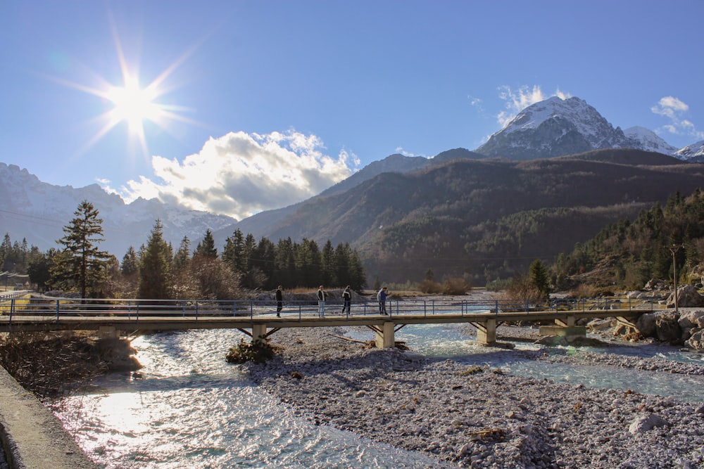 a bridge over a river with mountains in the background