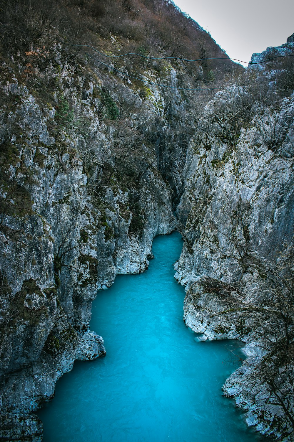 a river flowing through a canyon next to a lush green hillside