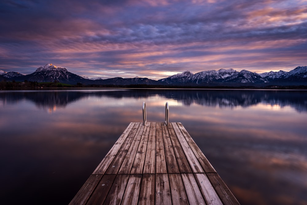 a dock on a lake with mountains in the background