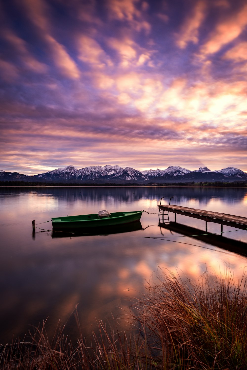 a green boat sitting on top of a body of water