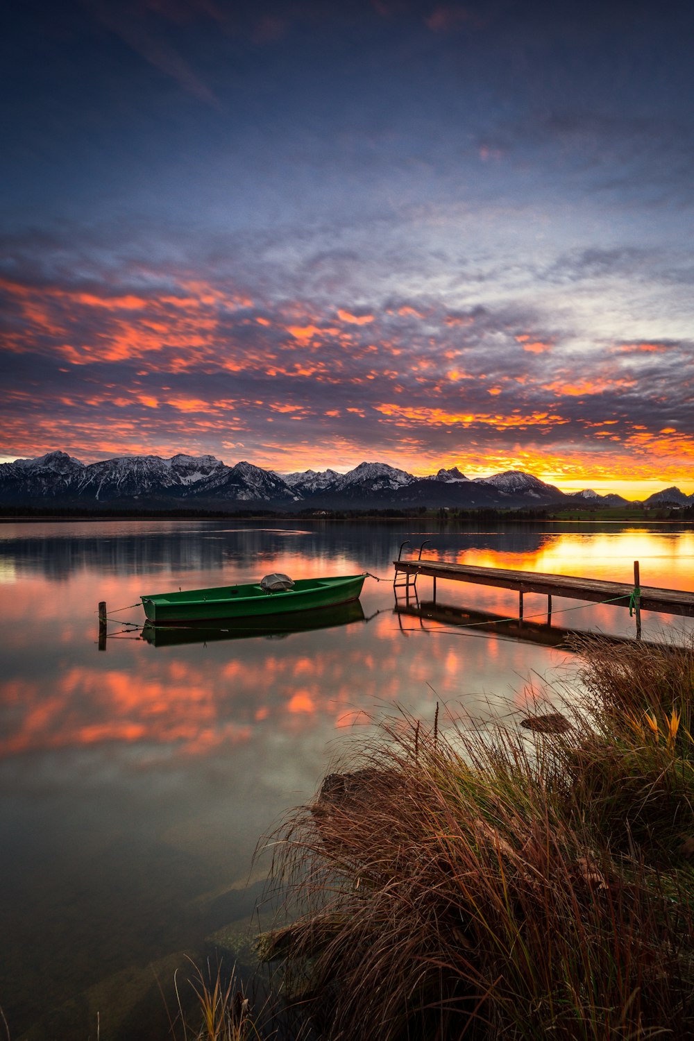 a green boat sitting on top of a body of water