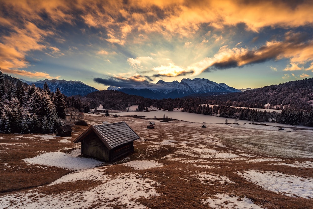 a small cabin sitting on top of a snow covered field