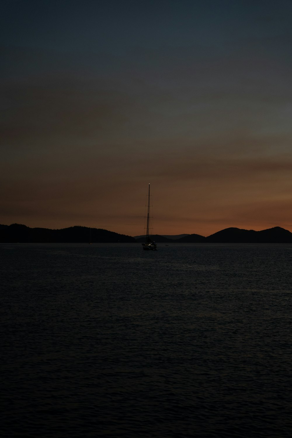 a sailboat is out on the water at sunset