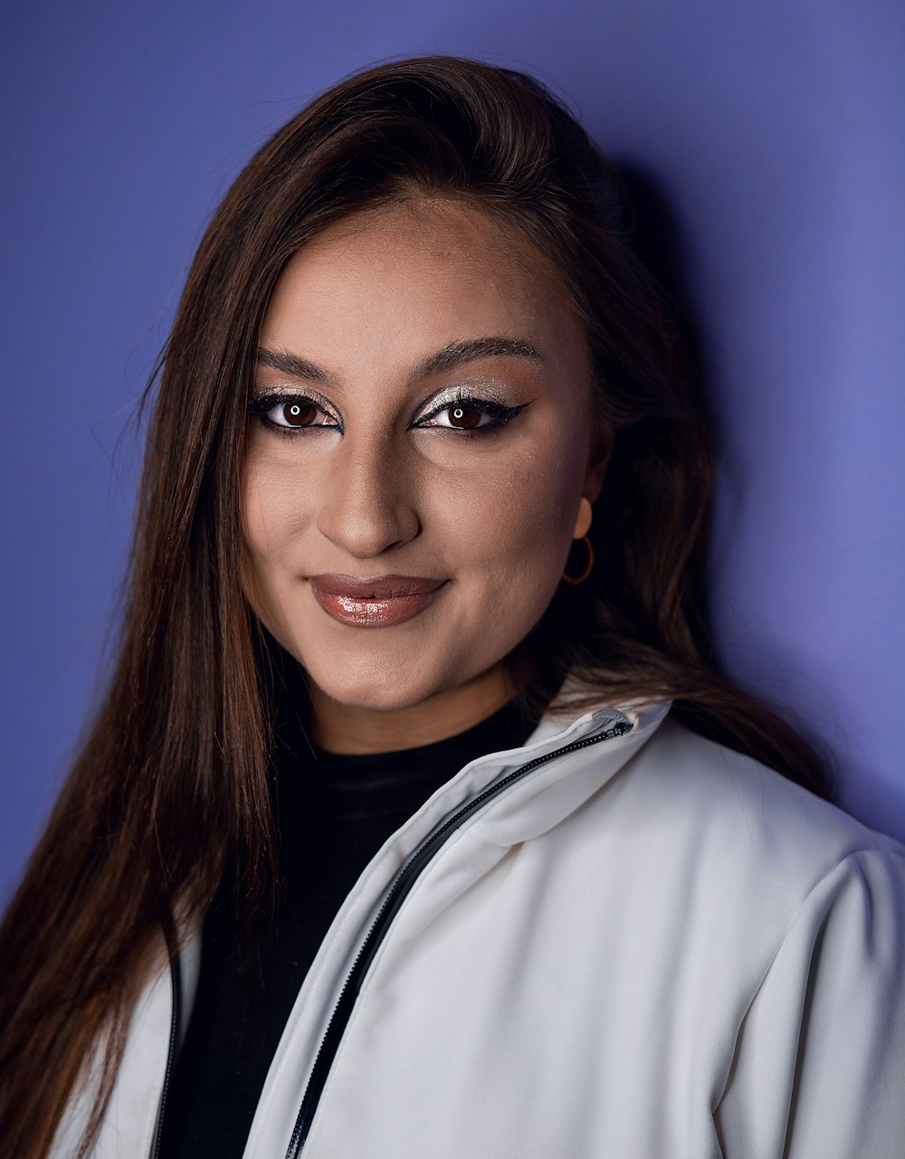 a woman wearing a white jacket and a black shirt