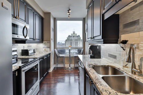 Before and after images of a stylish kitchen remodel in a city apartment.
