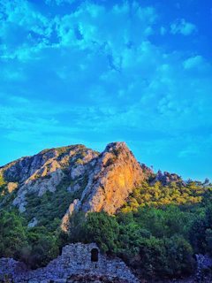 Golden sunlight bathes the ancient ruins of Bamiyan, framed by towering cliffs.