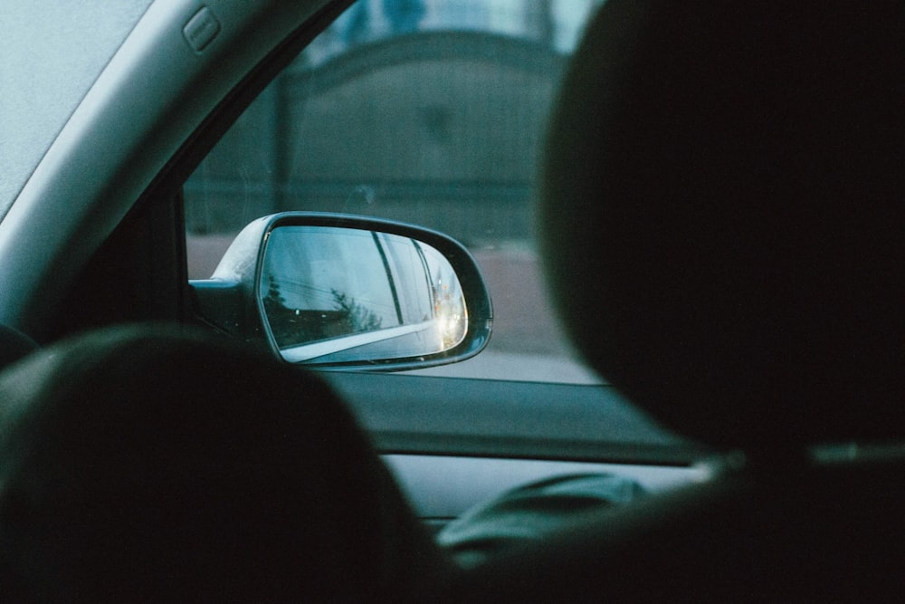 a rear view mirror on a car with a building in the background