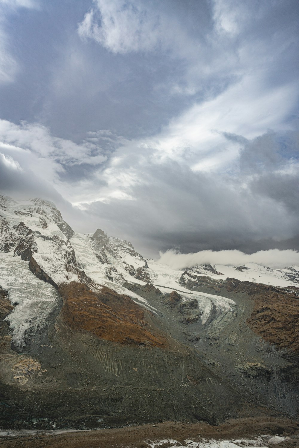 a snow covered mountain under a cloudy sky