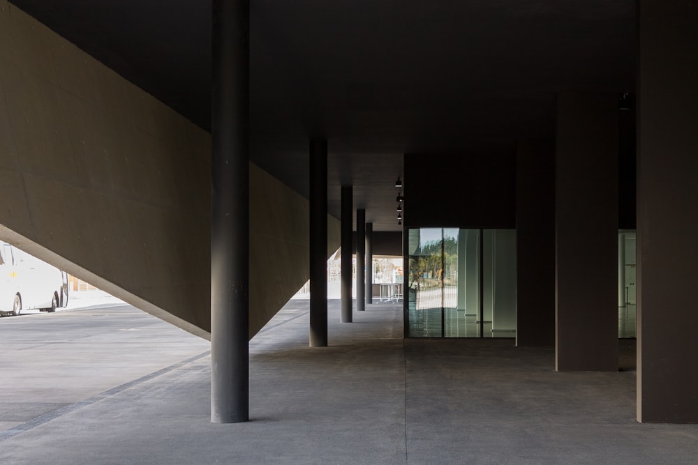 an empty building with columns and a bus in the background