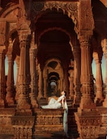 Elegant Indian call girl posing gracefully by a vintage hotel lobby.