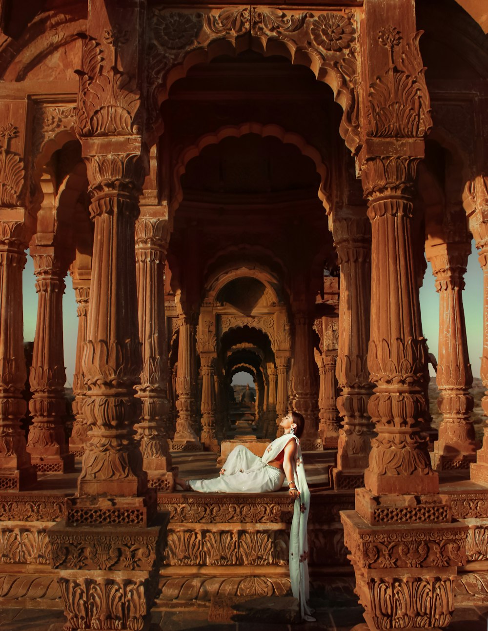 a woman in a white dress standing in front of a building