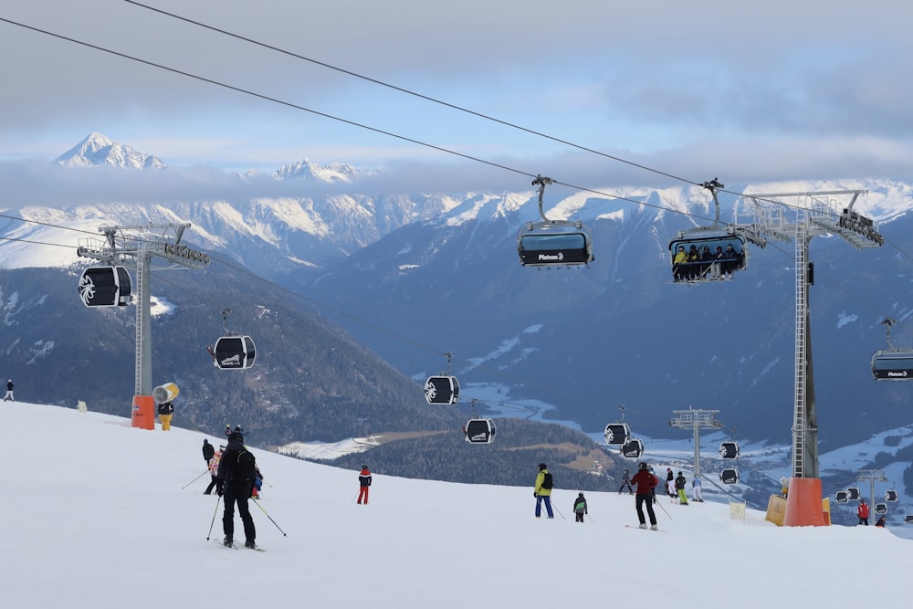 a group of people riding skis down a snow covered slope