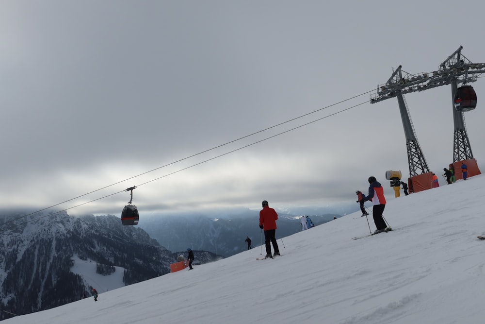 a group of people riding skis down a snow covered slope