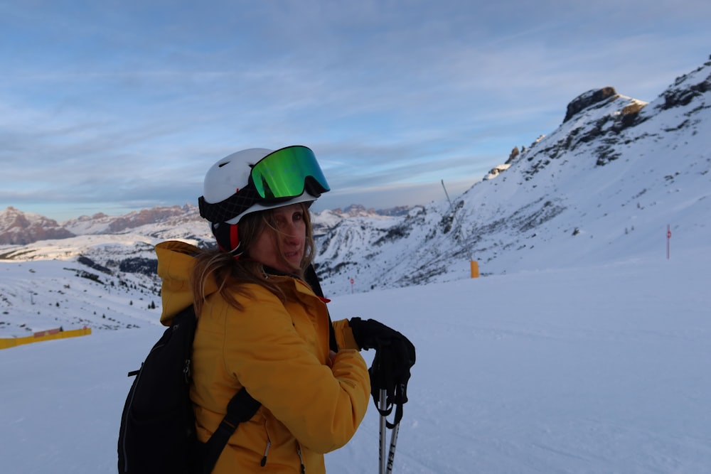 a person with a backpack and skis standing in the snow