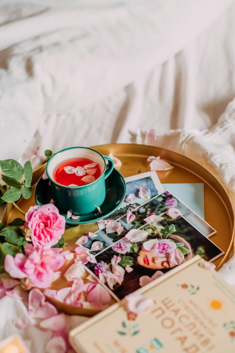 a tray with flowers, a cup of tea and a book on it