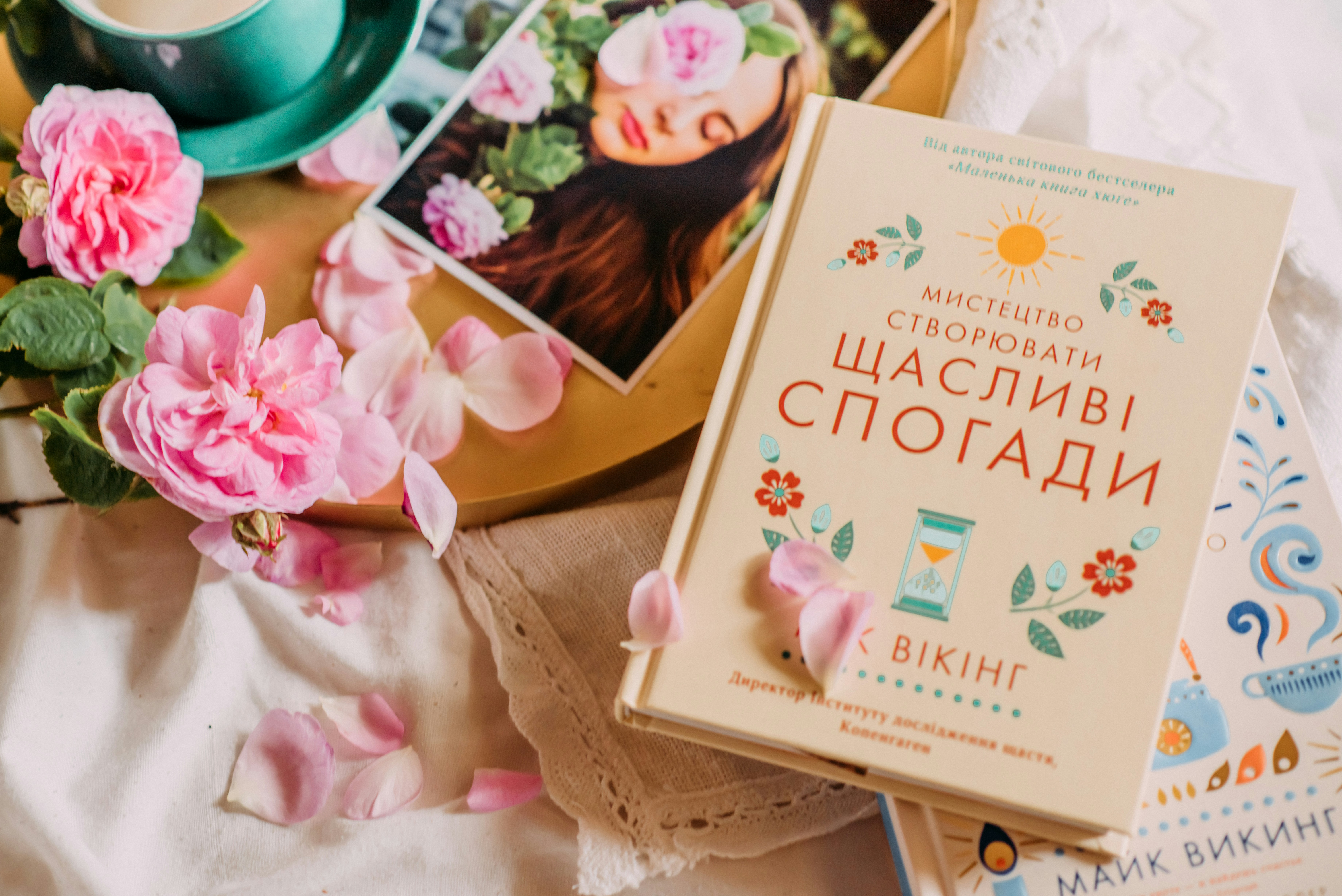 a book sitting on top of a table next to pink flowers