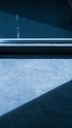 Close-up of a sleek vitrified tile with natural stone texture reflecting soft ambient light.