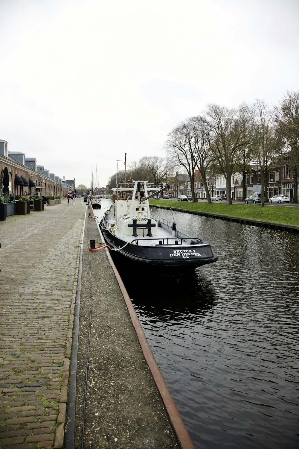 Un barco blanco y negro sentado al lado de un río