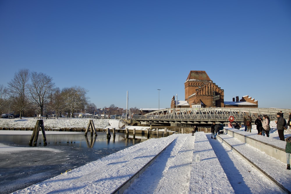 a group of people walking across a snow covered bridge