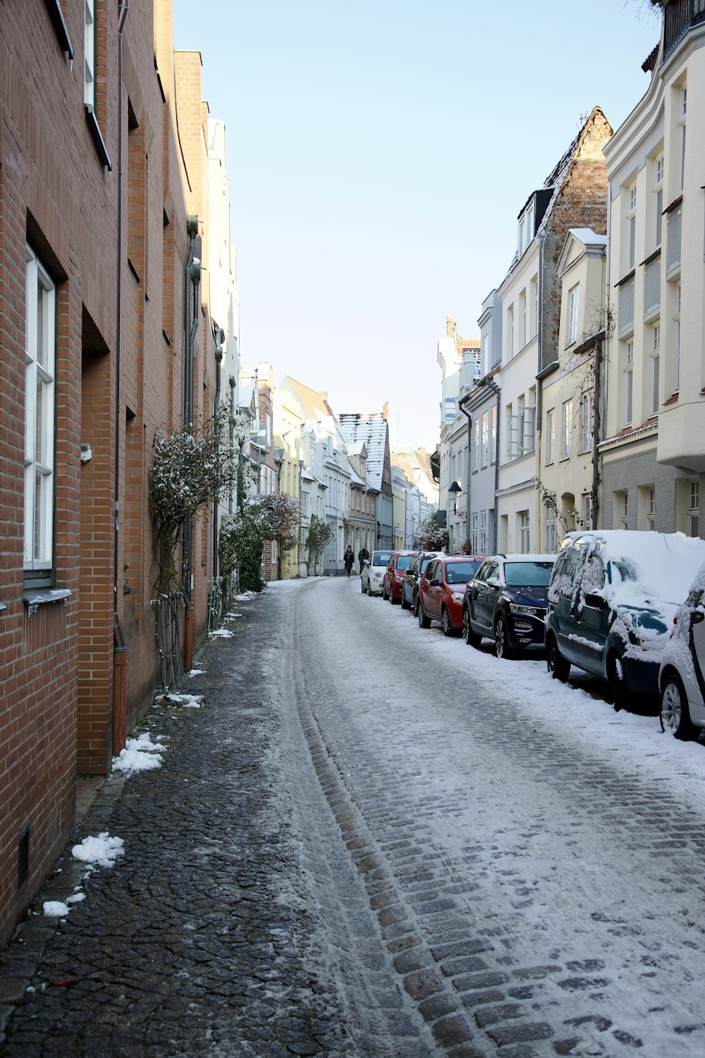 a row of parked cars on a snowy street