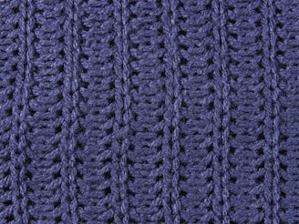 a close up of a blue knitted blanket