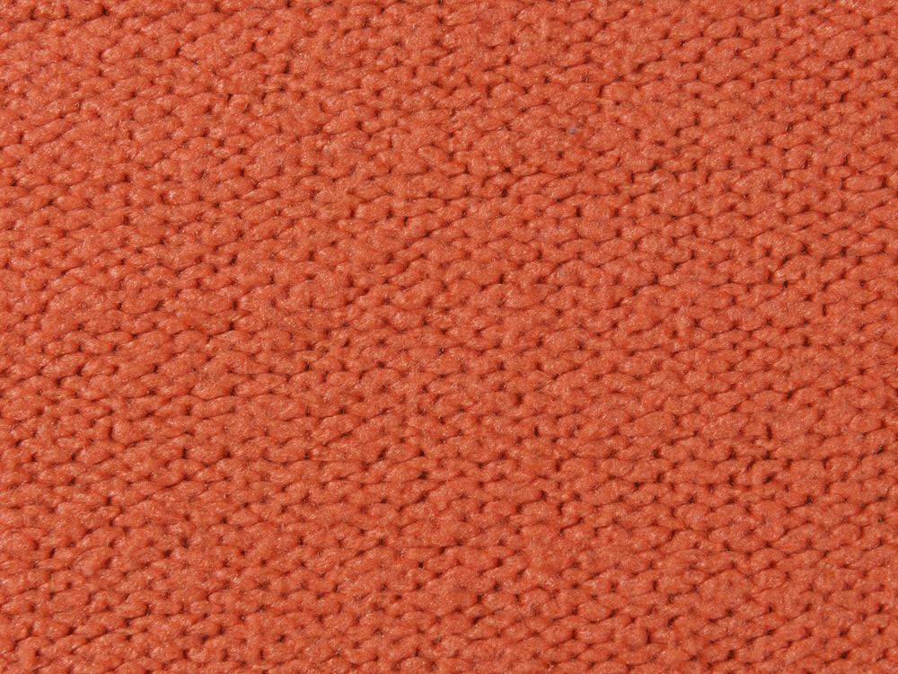 Eine Nahaufnahme einer orangefarbenen Teppichstruktur