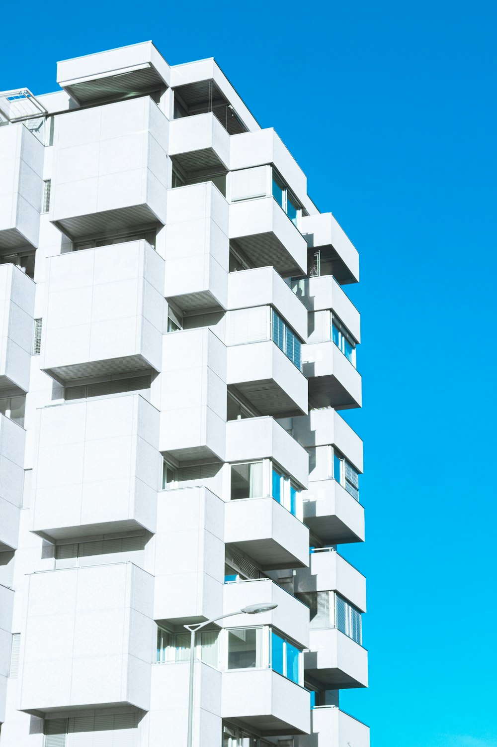 a tall white building with balconies and windows