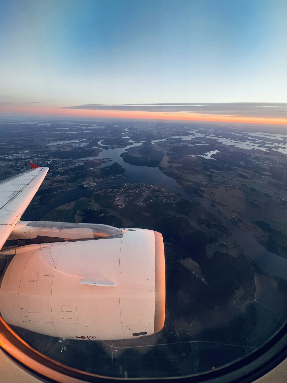 a view of the wing of an airplane as it flies over a river