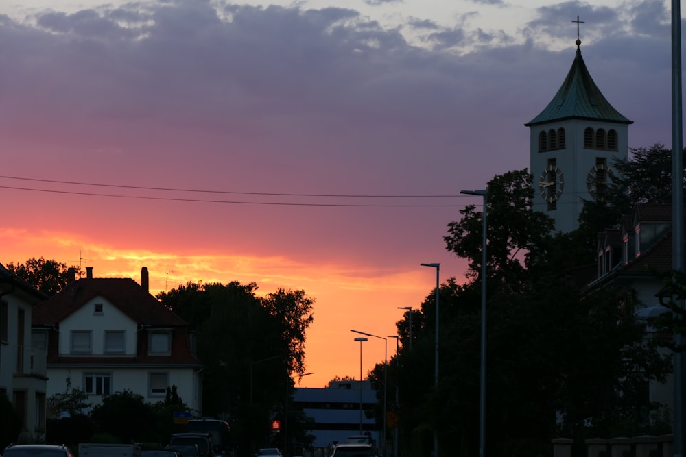 a sunset with a church steeple in the background