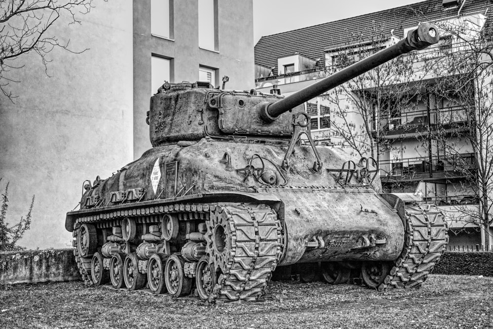 Una foto en blanco y negro de un tanque frente a un edificio