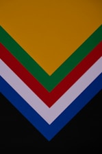 a close up of a stack of different colored papers