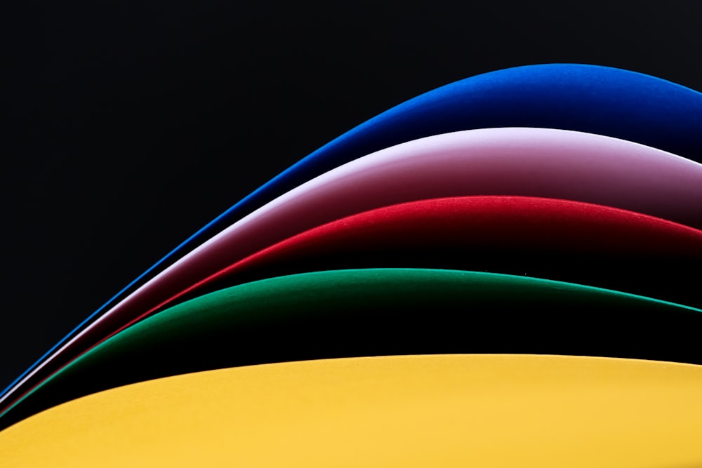 a stack of different colored papers on a black background